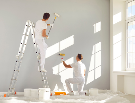 Two men painting a wall